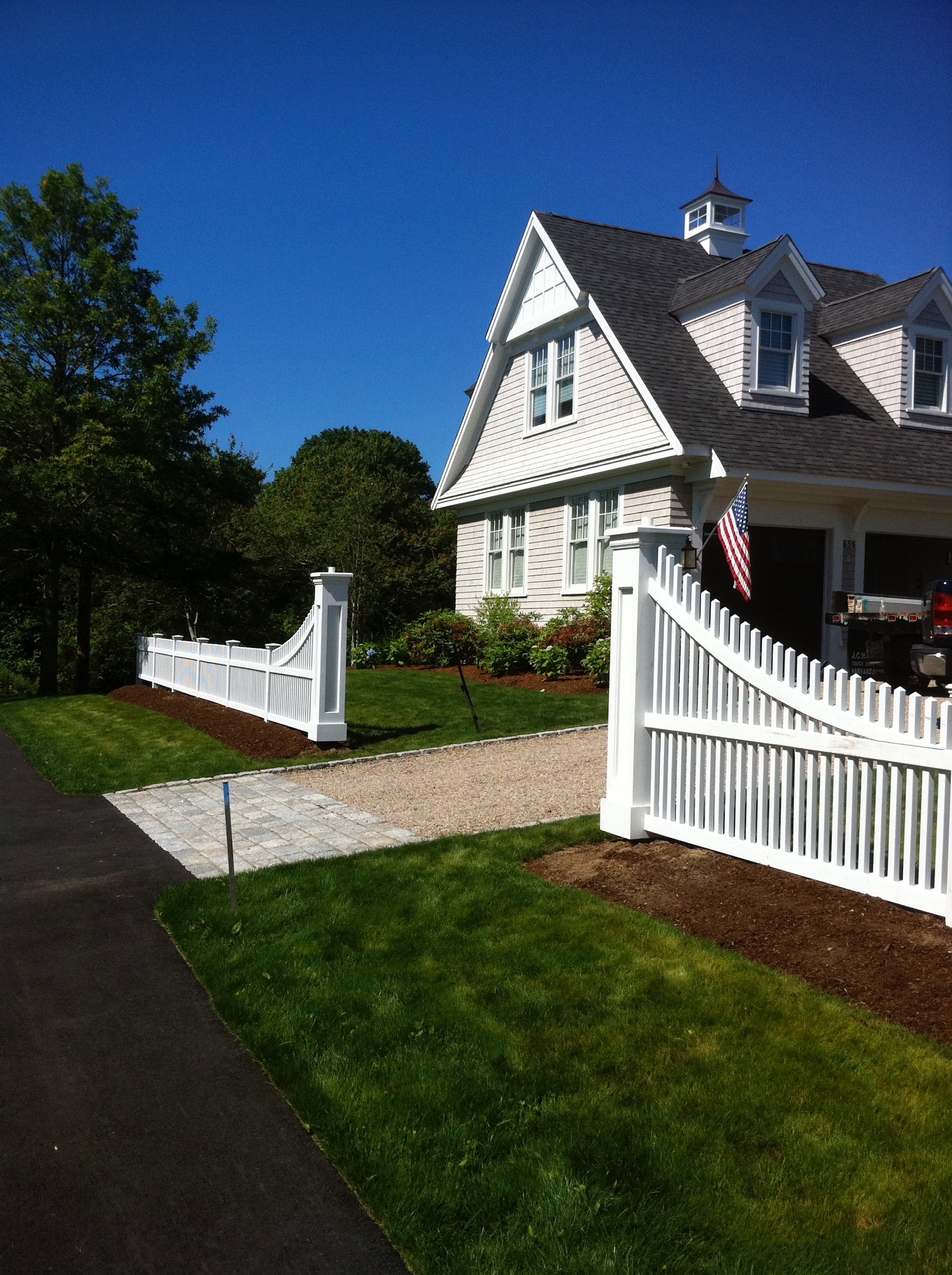 Pyramid picket fence with custom fence sweeps and genuine recessed panel columns